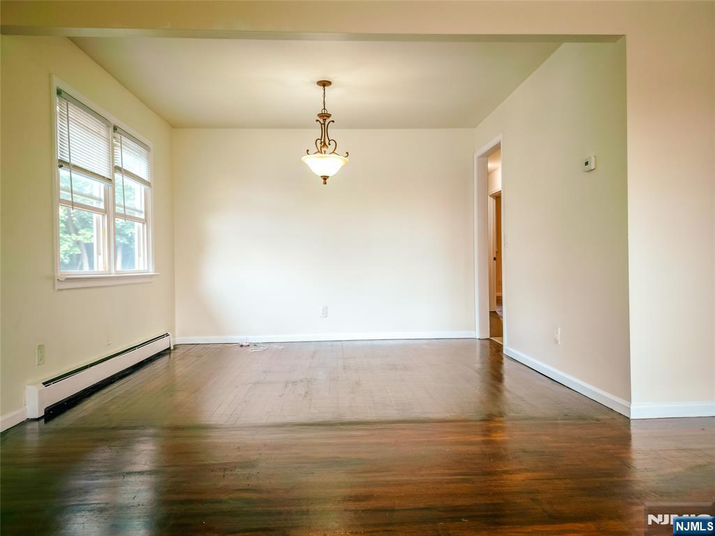 104 Eastern Way Rutherford, NJ 07070 - Photo 10 of 16 an empty room with wooden floor chandelier and windows