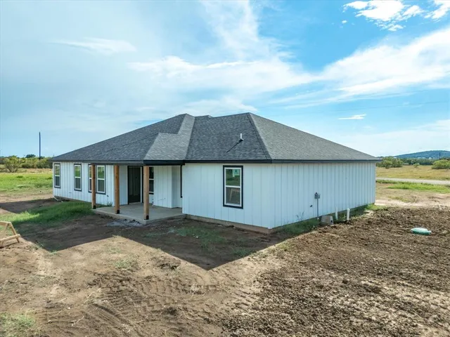 a backyard of a house with table and chairs