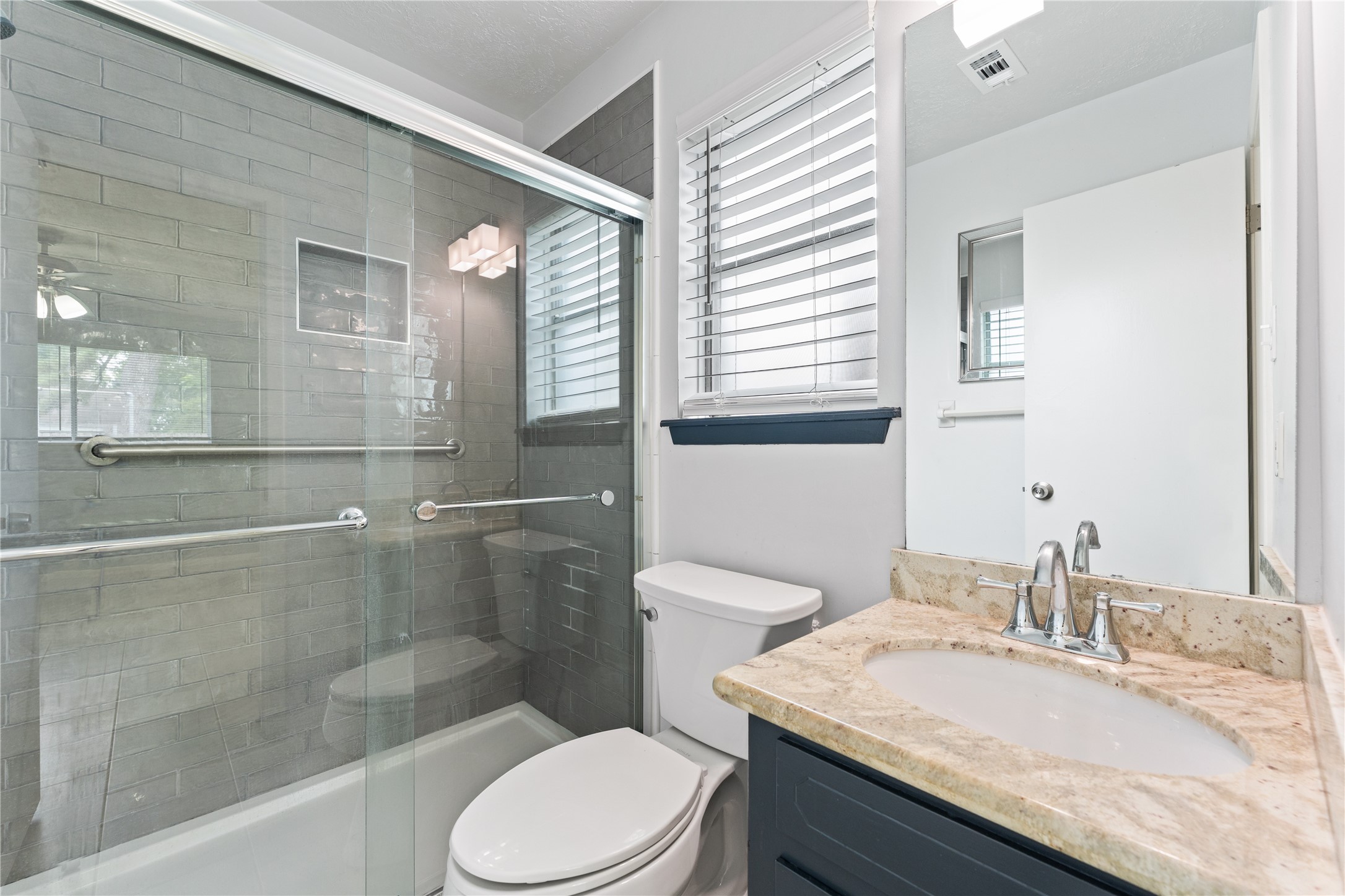 1431 Epsilon Street Pasadena, TX 77504 - Photo 18 of 21 a bathroom with a granite countertop sink a toilet a mirror and shower