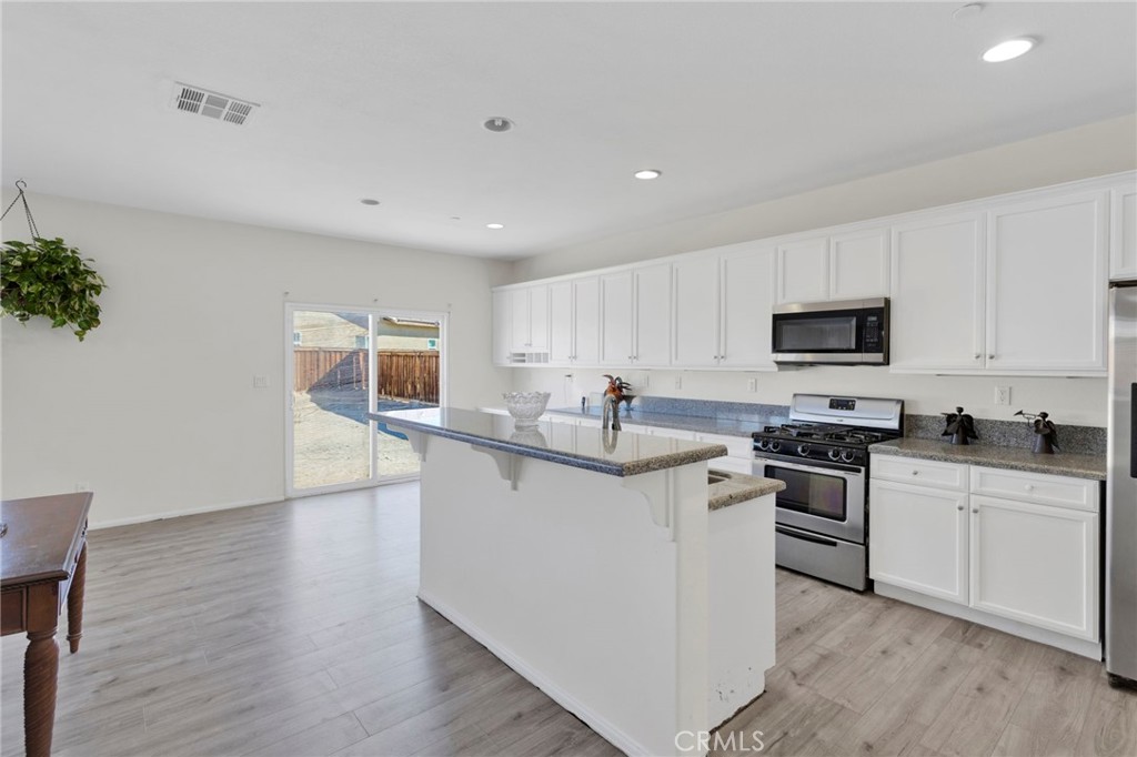 14245 Purple Canyon Road Adelanto, CA 92301 - Photo 13 of 38 a kitchen with stainless steel appliances a sink dishwasher stove refrigerator and microwave