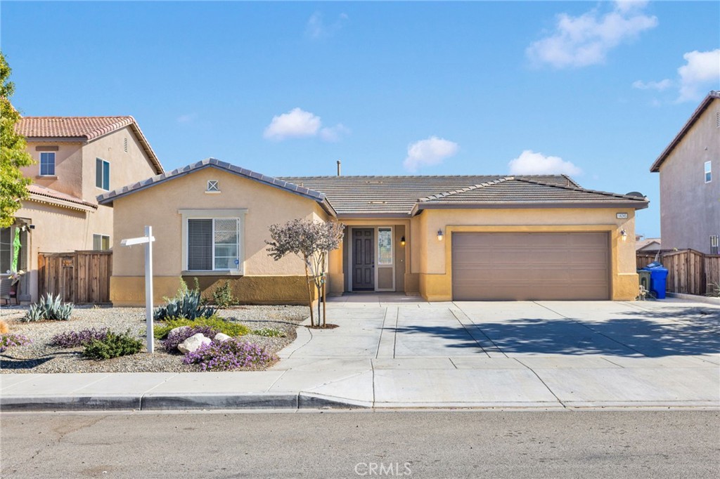 14245 Purple Canyon Road Adelanto, CA 92301 - Photo 2 of 38 a front view of a house with a garden and plants