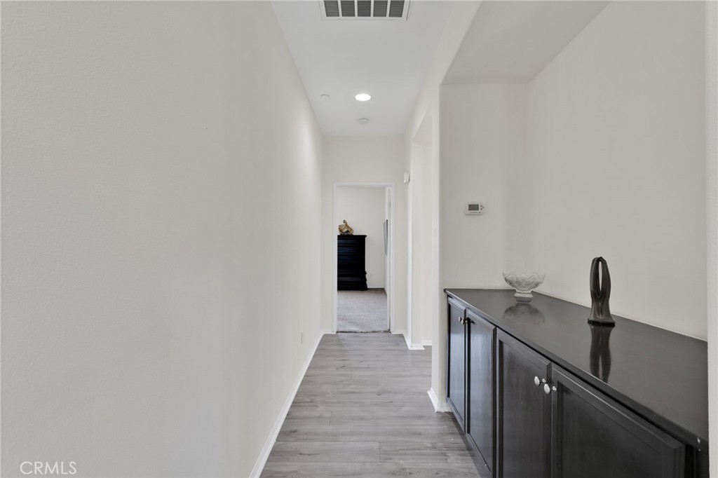 14245 Purple Canyon Road Adelanto, CA 92301 - Photo 24 of 38 a hallway with a sink and wooden floor