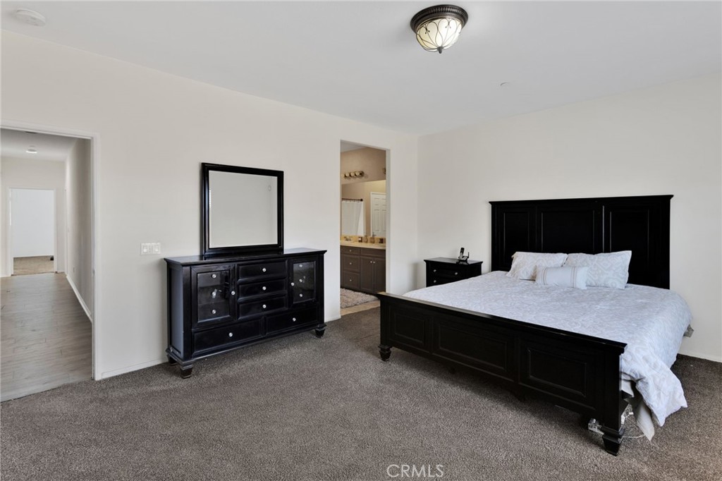 14245 Purple Canyon Road Adelanto, CA 92301 - Photo 26 of 38 a spacious bedroom with a bed and a dresser