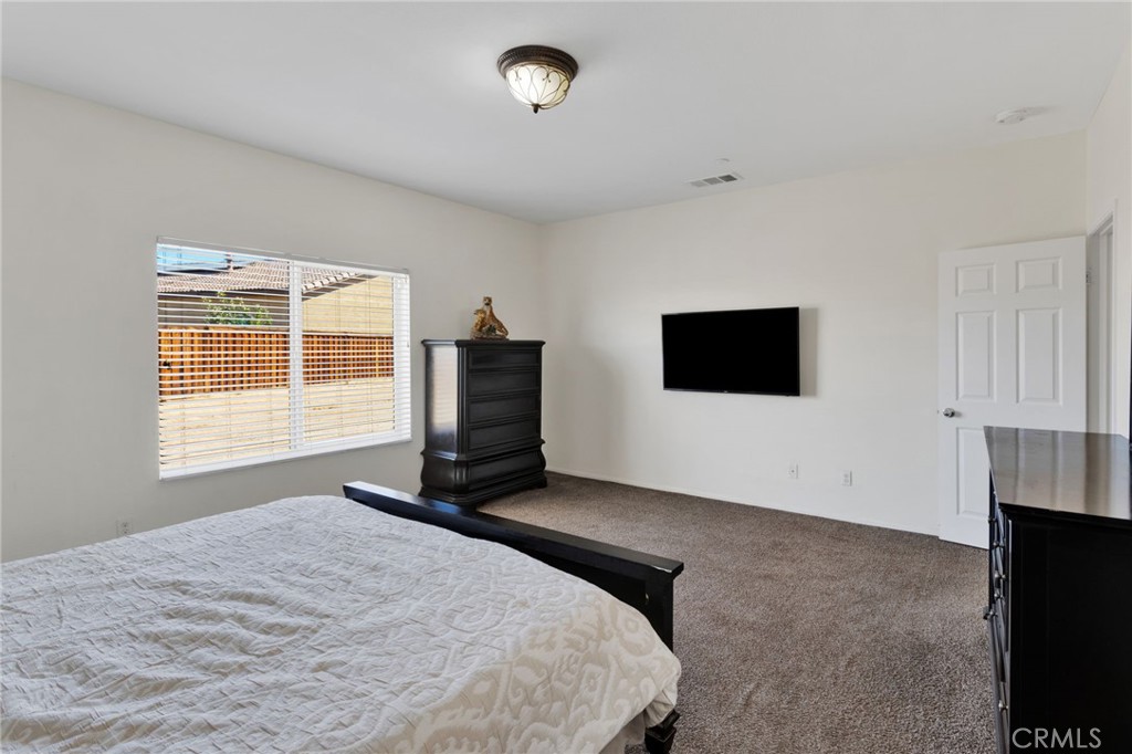 14245 Purple Canyon Road Adelanto, CA 92301 - Photo 27 of 38 a bedroom with a bed a television and a window