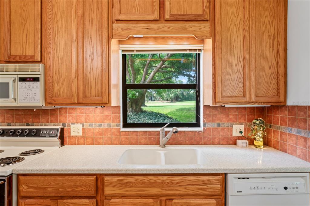 9108 Bassett Lane, Unit B New Port Richey, FL 34655 - Photo 11 of 66 a kitchen with granite countertop wooden cabinets a sink and a window