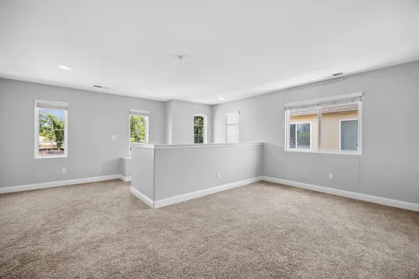 a view of an empty room and chandelier fan