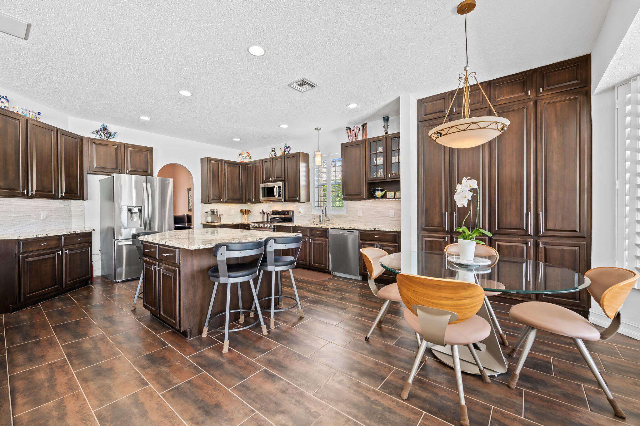12781 Yardley Drive Boca Raton, FL 33428 - Photo 11 of 55 a dining area with a table chairs and a kitchen view