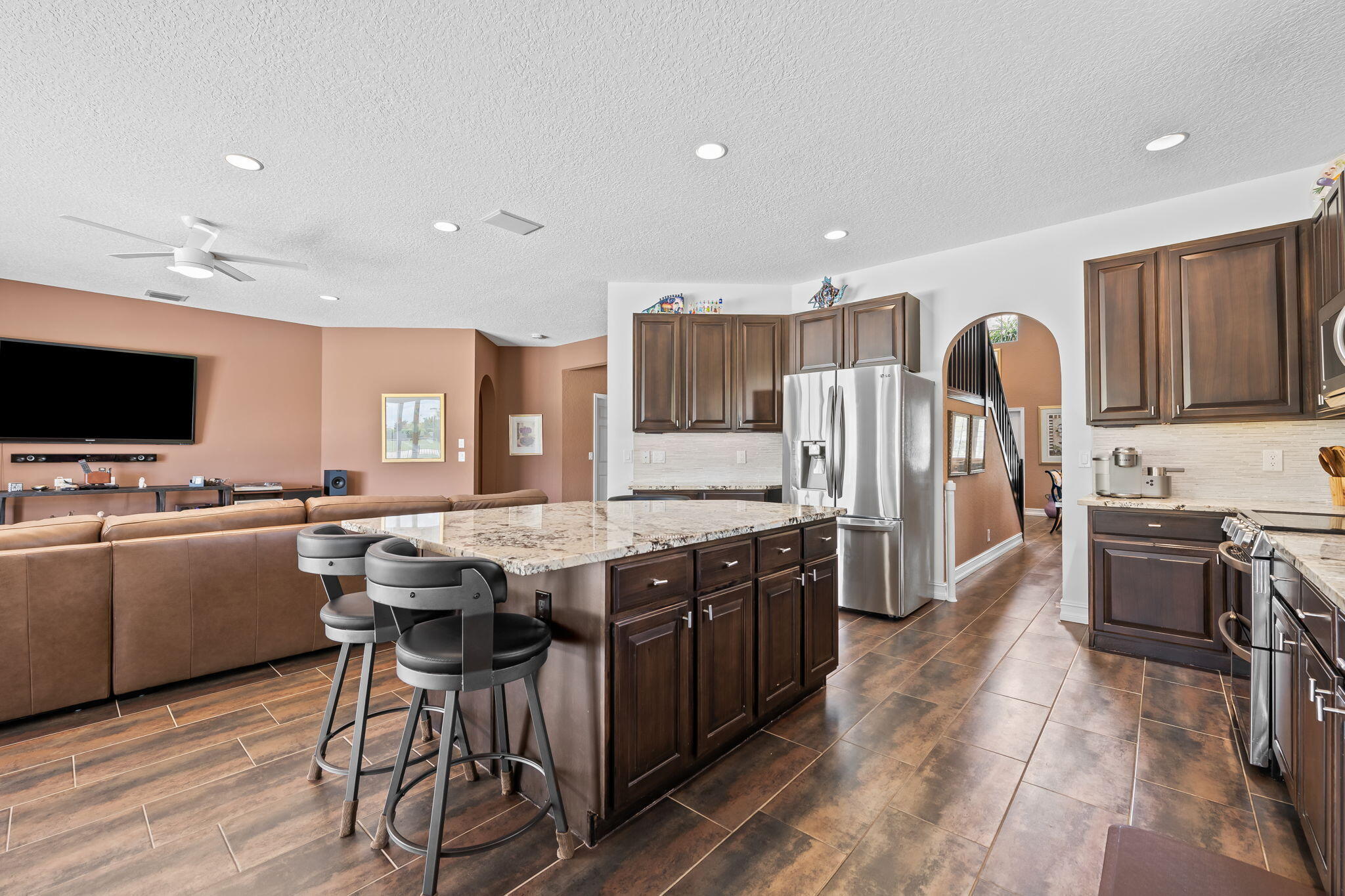 12781 Yardley Drive Boca Raton, FL 33428 - Photo 12 of 55 a kitchen with stainless steel appliances granite countertop a stove top oven a sink dishwasher a dining table and chairs with wooden floor