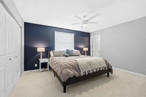 a bedroom with a bed and ceiling fan
