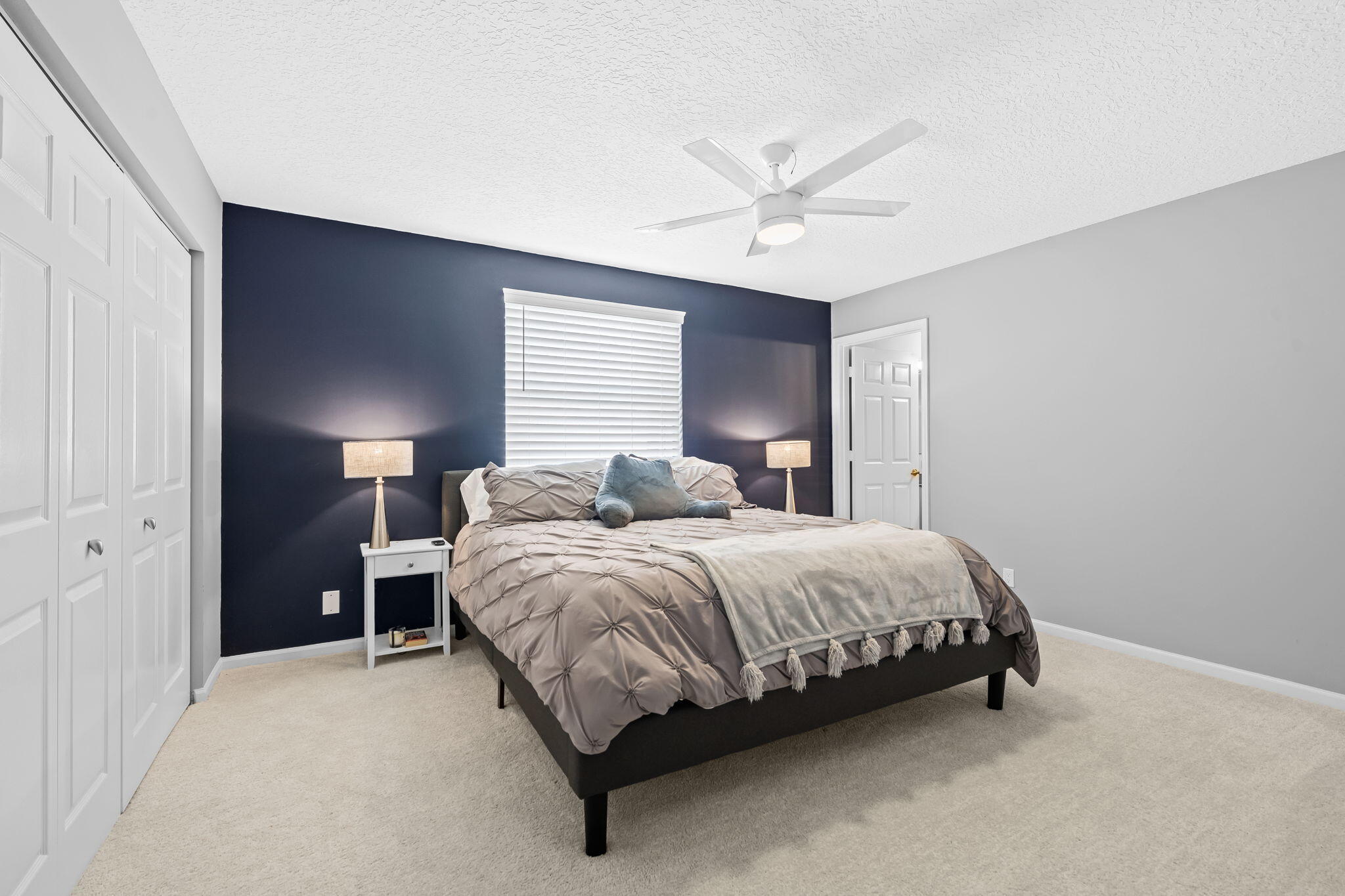 12781 Yardley Drive Boca Raton, FL 33428 - Photo 21 of 55 a spacious bedroom with a bed and a chandelier