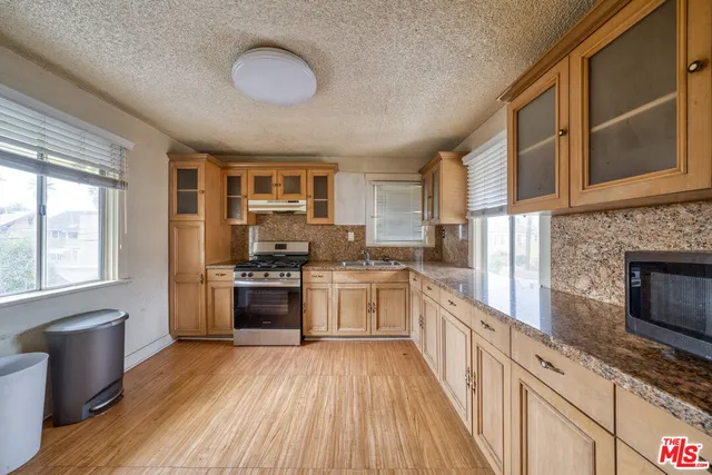 a kitchen with stainless steel appliances granite countertop a stove and cabinets