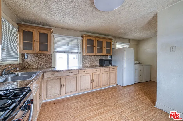 a kitchen with granite countertop a sink stove and refrigerator