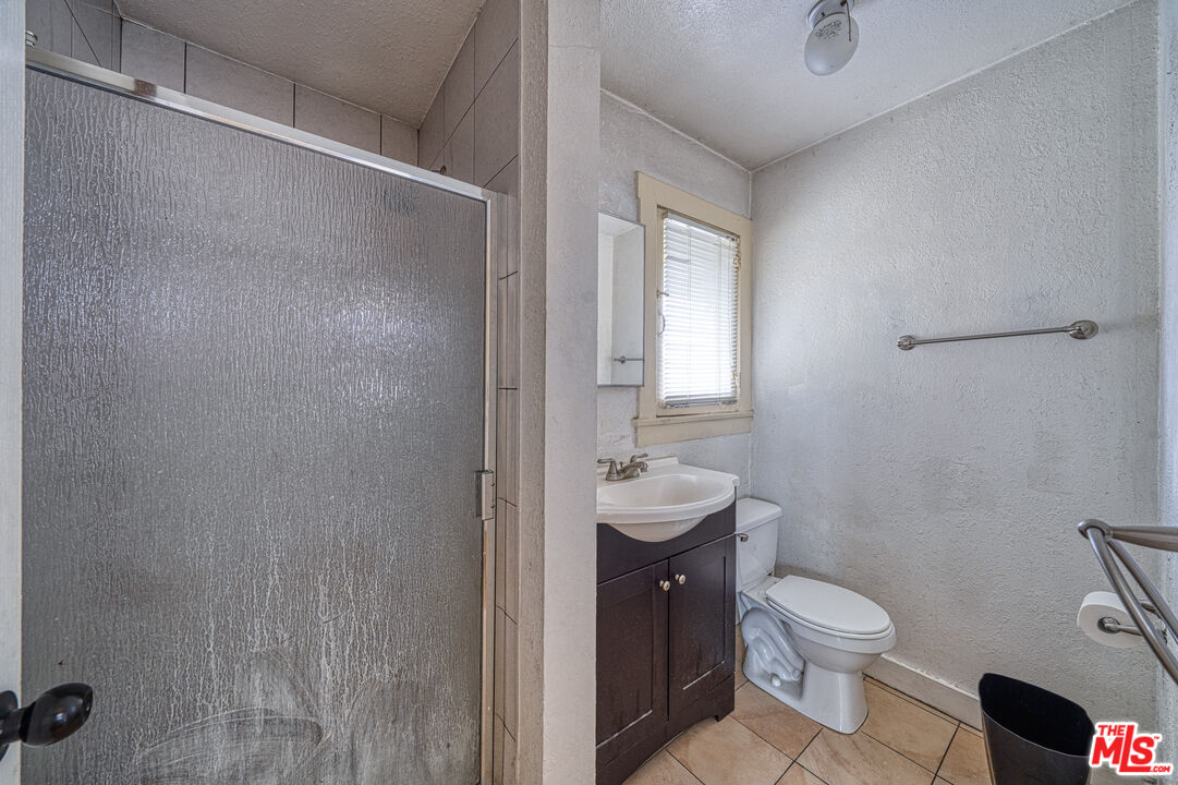 1677 South Harvard Boulevard, Unit UPSTAIRS Los Angeles, CA 90006 - Photo 16 of 19 a bathroom with a toilet a sink and mirror