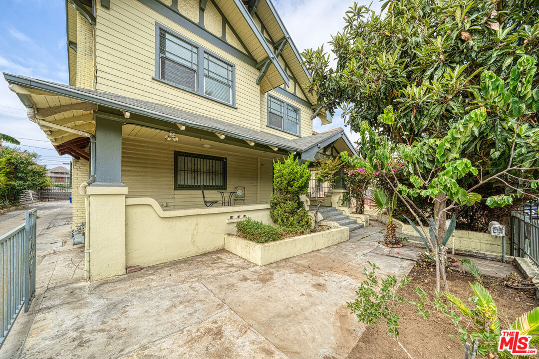 1677 South Harvard Boulevard, Unit UPSTAIRS Los Angeles, CA 90006 - Photo 3 of 19 a view of a white house with a large tree