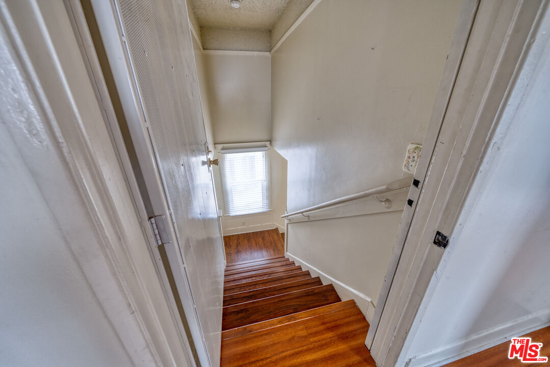 1677 South Harvard Boulevard, Unit UPSTAIRS Los Angeles, CA 90006 - Photo 7 of 19 a view of staircase with white walls and railing