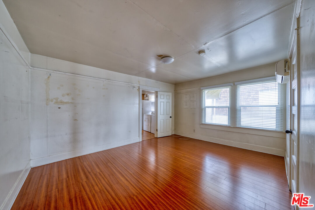 1677 South Harvard Boulevard, Unit UPSTAIRS Los Angeles, CA 90006 - Photo 9 of 19 an empty room with wooden floor and windows