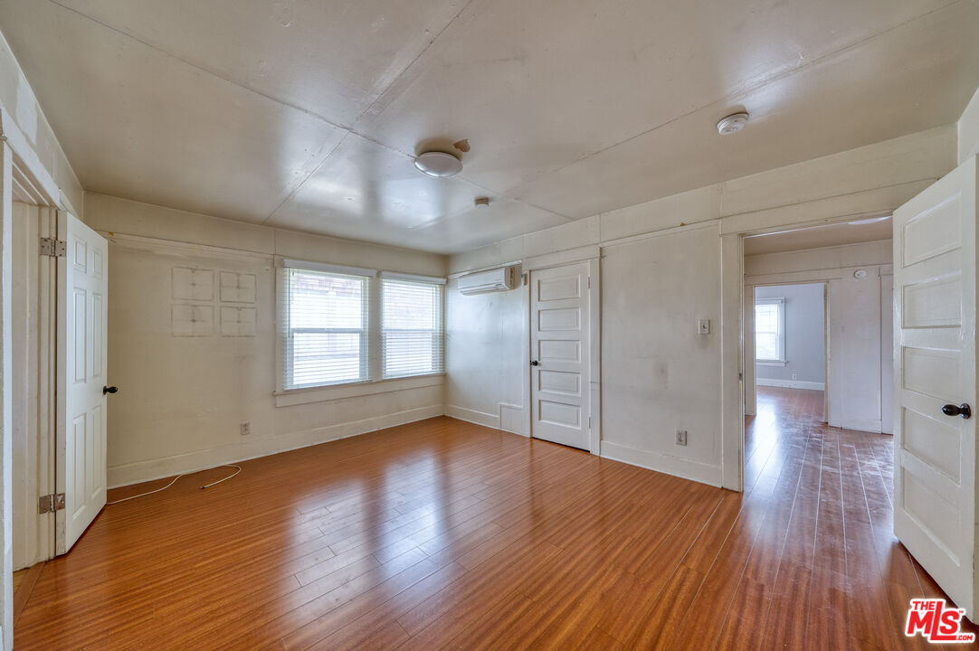 1677 South Harvard Boulevard, Unit UPSTAIRS Los Angeles, CA 90006 - Photo 10 of 19 a view of an empty room with wooden floor and a window