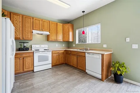 a kitchen with a white stove top oven sink and cabinets