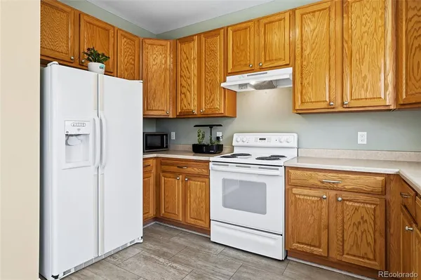 a kitchen with stainless steel appliances granite countertop white refrigerator stove top oven and cabinets