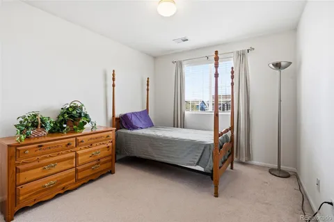 a bedroom with a bed and a potted plant