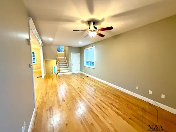 a view of a room with wooden floor and ceiling fan
