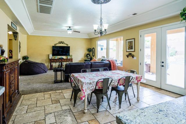 3683 South 2640 West St. George, UT 84790 - Photo 17 of 41 Spacious living area featuring stone-look flooring, carpeted lounge, a decorative chandelier, and double glass-paneled doors opening to the exterior