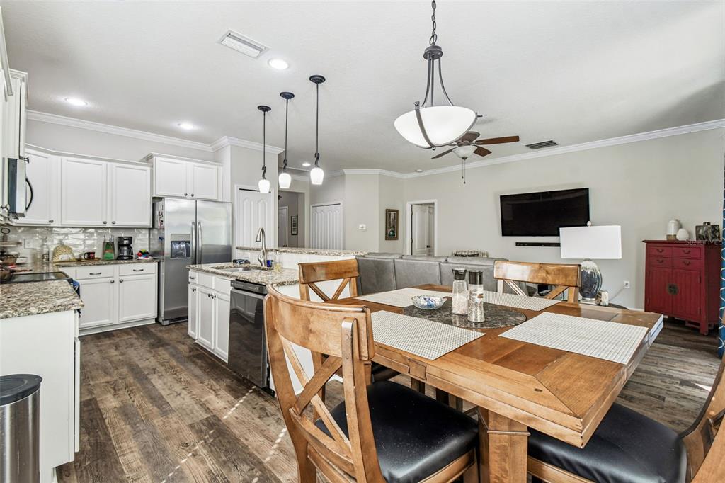 11150 Paradise Pointe Way New Port Richey, FL 34654 - Photo 12 of 91 a open kitchen with stainless steel appliances granite countertop a stove kitchen island a dining table and chairs