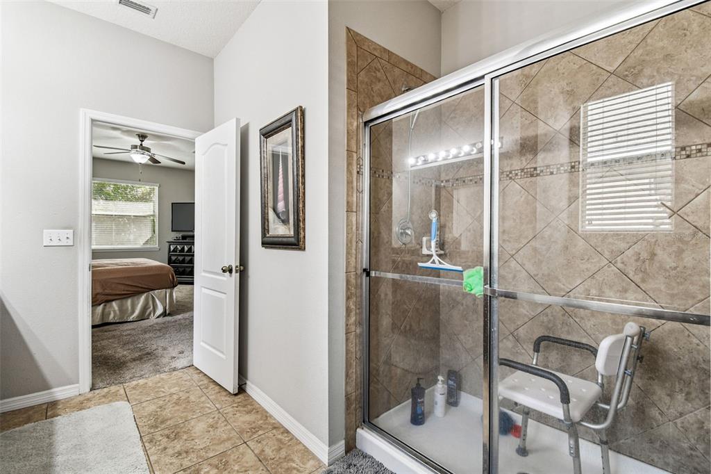 11150 Paradise Pointe Way New Port Richey, FL 34654 - Photo 34 of 91 a bathroom with a glass shower door and a mirror