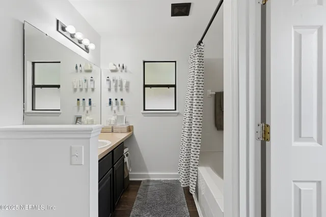 a bathroom with a granite countertop sink a mirror and a shower