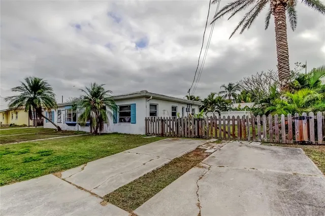 a front view of a house with a garden and yard
