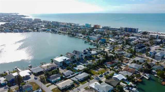 an aerial view of a city with ocean view in back