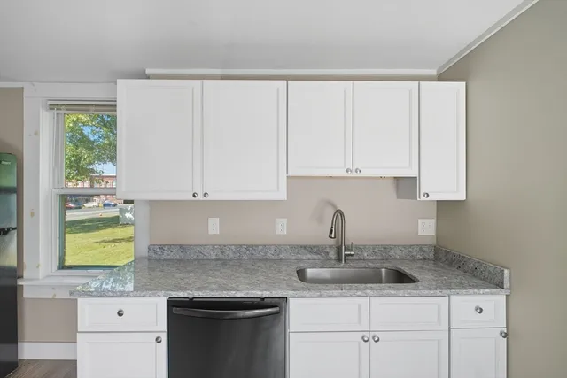 a kitchen with stainless steel appliances granite countertop a sink a stove and cabinets