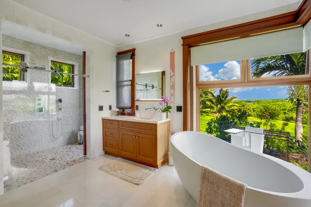 a large white tub sitting in a bathroom next to a window