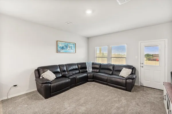 a living room with furniture and kitchen view