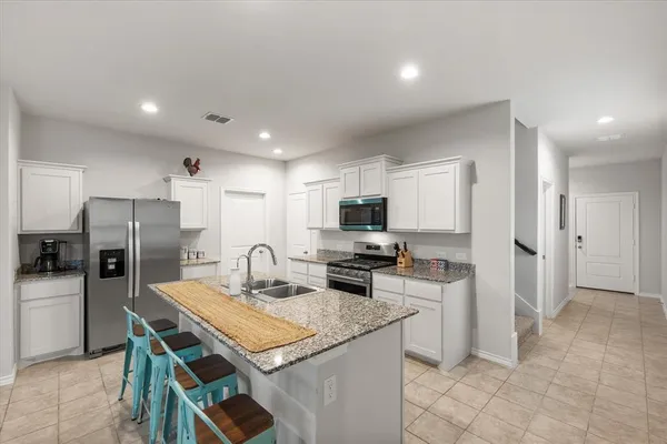 a kitchen with stainless steel appliances a stove refrigerator sink and microwave