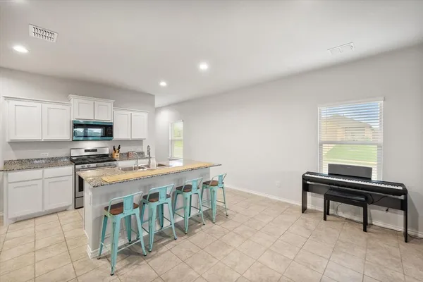 a kitchen with cabinets and chairs