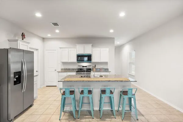 a kitchen with sink refrigerator and microwave