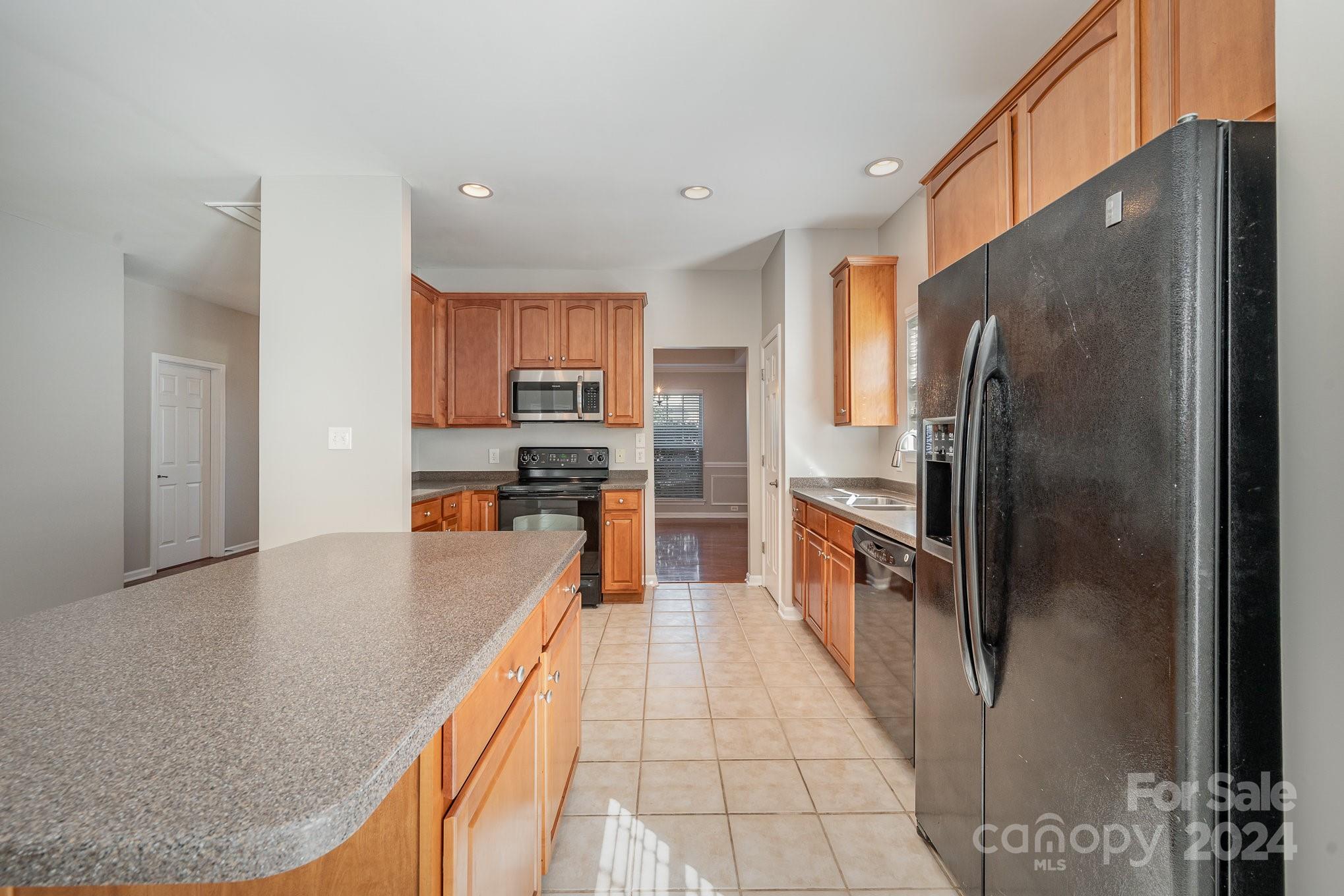 13341 Meadowmere Road Huntersville, NC 28078 - Photo 7 of 22 a large kitchen with kitchen island a large counter top stainless steel appliances and cabinets