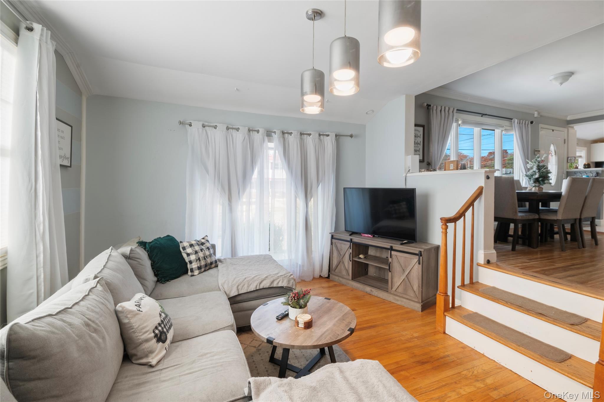 277 Horseblock Road Farmingville, NY 11738 - Photo 9 of 28 Living area with light wood-style floors, crown molding, and stairs