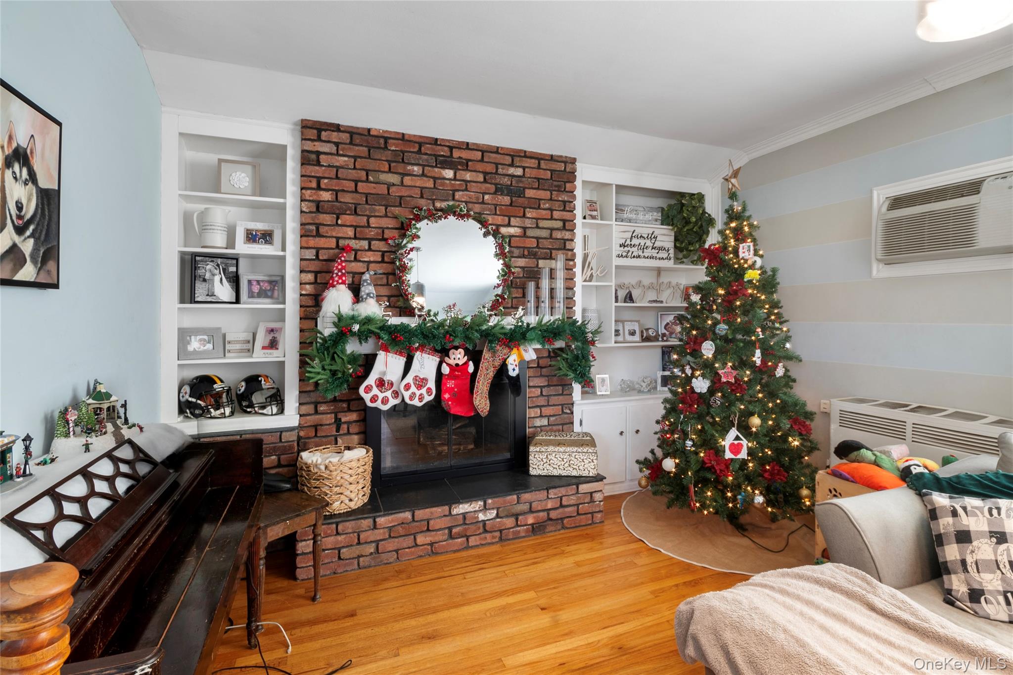 277 Horseblock Road Farmingville, NY 11738 - Photo 10 of 28 Living room with built in features, a fireplace, hardwood / wood-style floors, and a wall mounted AC