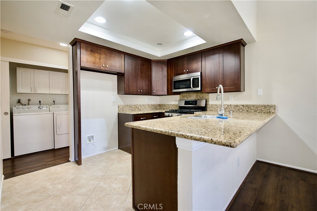 407 Tangelo Irvine, CA 92618 - Photo 4 of 30 a kitchen with kitchen island granite countertop a stove and a refrigerator