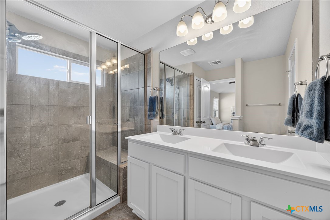 201 Cane River Road Pflugerville, TX 78660 - Photo 10 of 21 a bathroom with a shower sink vanity granite and mirror