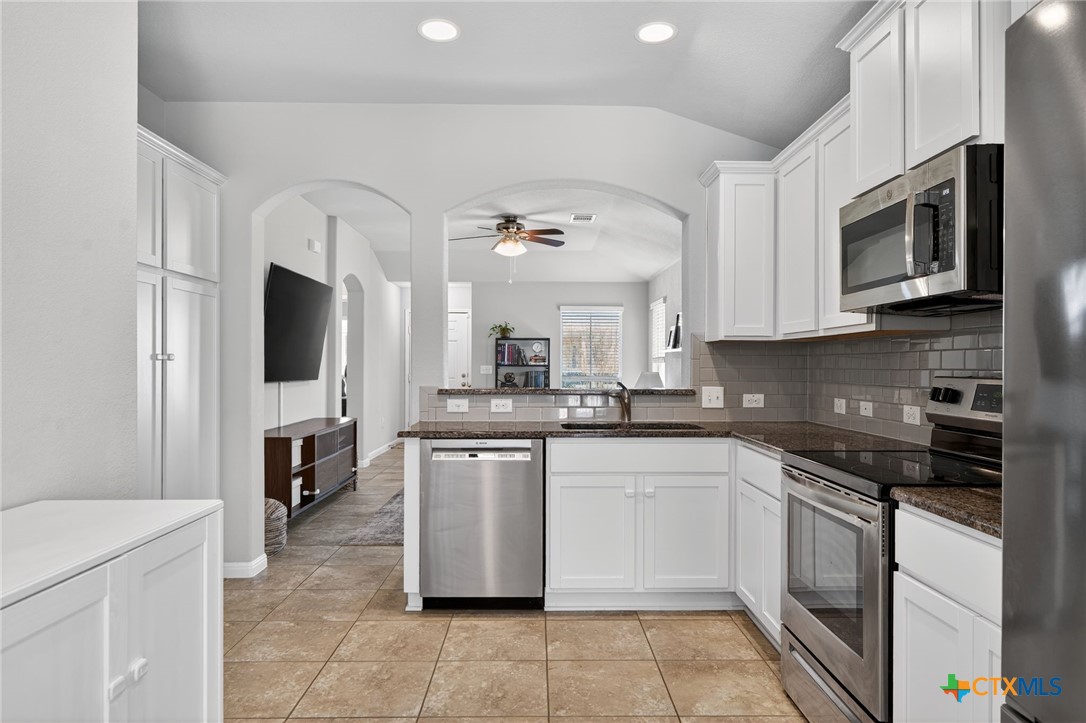 201 Cane River Road Pflugerville, TX 78660 - Photo 6 of 21 a kitchen with stainless steel appliances a stove microwave and a sink
