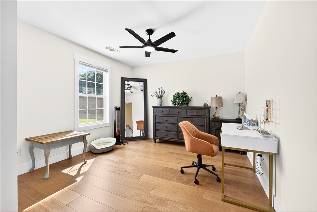 5016 Copeland Road Belton, SC 29627 - Photo 29 of 45 Hardwood floors and a large window create a comfortable, sun-drenched room, perfect for rest or productivity.