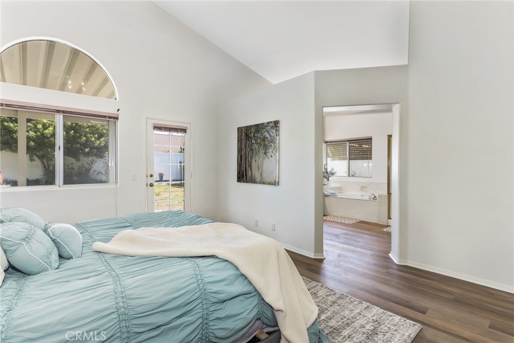 8742 Feathertop Road Riverside, CA 92508 - Photo 28 of 40 Main bedroom leading to ensuite of bathtub, private toilet, shower and double sinks! Brand new hard flooring! Note the special fan shape window and door leading to your backyard... your private retreat!