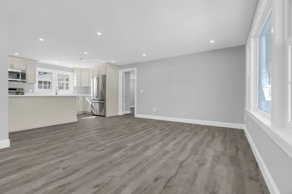 a view of a kitchen with wooden floor and a window