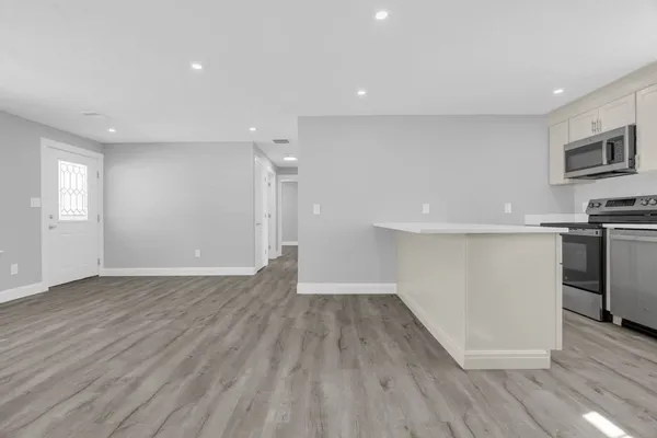 a view of a kitchen with wooden floor and a sink