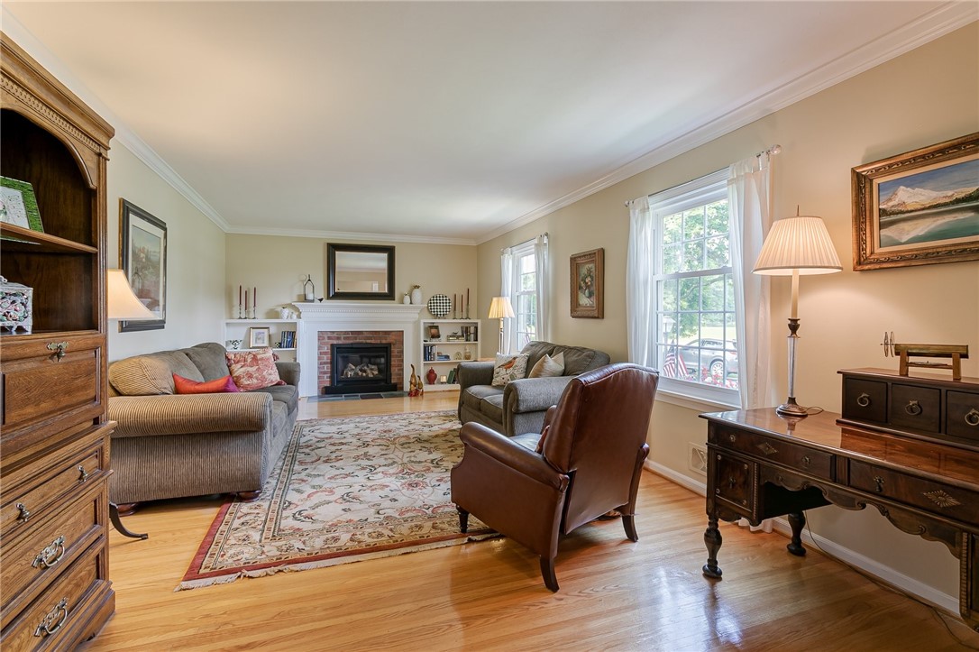 2024 Baird Road Penfield, NY 14526 - Photo 10 of 37 Living room with custom gas fireplace surrounded b