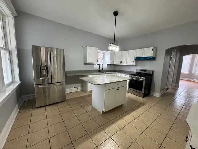 a kitchen with stainless steel appliances granite countertop a sink a stove a refrigerator and cabinets