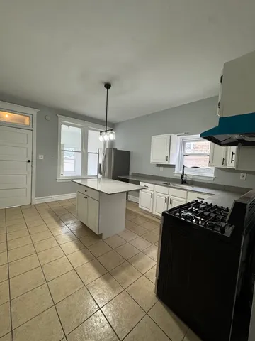 a kitchen with stainless steel appliances a stove a sink and a refrigerator